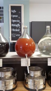Glasballons mit Essigen und Ölen auf einem Tresen